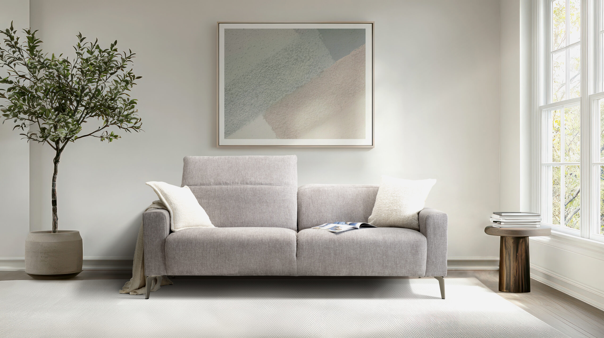 A white couch sits in front of a large white wall with a picture